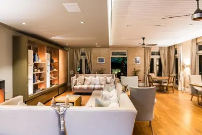a living room with a white couch and chairs at Angala in Simondium