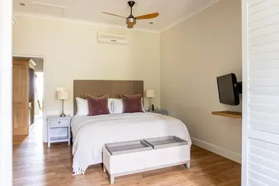 a bedroom with a bed and a tv on a wall at Angala in Simondium