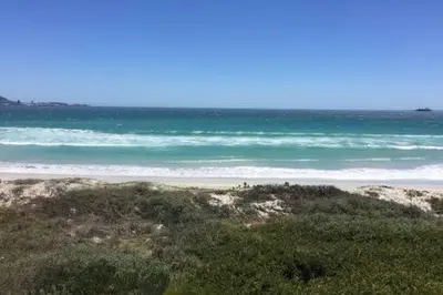 a sandy beach with the ocean in the background at 325 Leisure Bay Cape Town in Cape Town