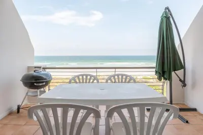a table and chairs on a balcony with the ocean at 325 Leisure Bay Cape Town in Cape Town