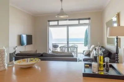 a living room with a table and a couch at 325 Leisure Bay Cape Town in Cape Town
