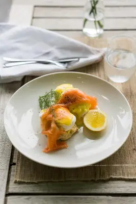 a white plate with food on a wooden table at Cape Vue Country House in Franschhoek