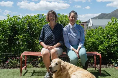 two women sitting on a bench with a dog at 29 Earlibelle in Stellenbosch