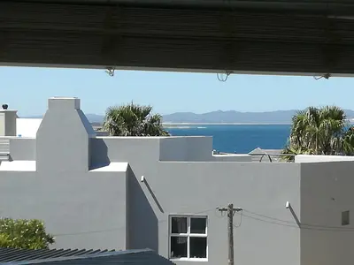 a view of the ocean from a white building at Siesta in Hermanus