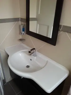 a white sink in a bathroom with a mirror at Nautilus Guest House in Hermanus