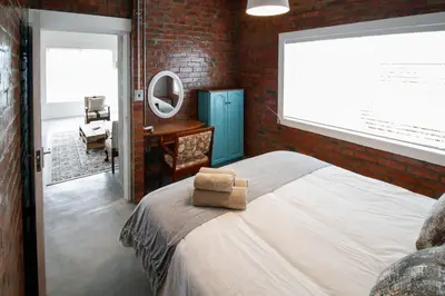 a bedroom with a large bed and a mirror at Rustic Retreat Apartment in Durbanville in Durbanville