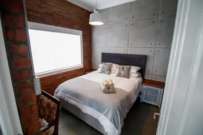 a bedroom with a bed with two shoes on it at Rustic Retreat Apartment in Durbanville in Durbanville