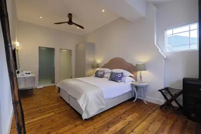 a bedroom with a bed and a ceiling fan at Chapter House Boutique Hotel by The Living Journey Collection in Franschhoek
