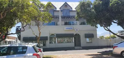 a white building with cars parked in front of it at Bedrock Guest Studios in Strand