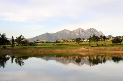 a view of a lake with mountains in the background at Devonvale Golf & Wine Estate in Stellenbosch