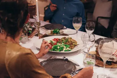 a woman sitting at a table with a plate of food at La Clé Lodge in Franschhoek