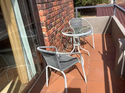 two chairs and a table on a balcony at Studio with unforgettable View in Gordonʼs Bay