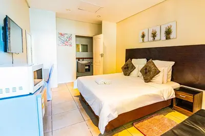 a bedroom with a bed and a television in it at Cape Town Milnerton Lagoon Villa in Cape Town