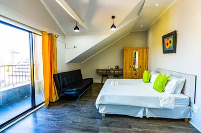 a bedroom with a bed and a chair and a window at Cape Town Milnerton Lagoon Villa in Cape Town