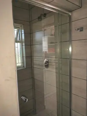 a shower with a glass door in a bathroom at Feet Up Cottage in Somerset West