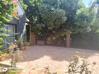 a patio with a fence and some plants at Feet Up Cottage in Somerset West
