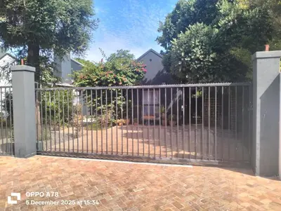 a metal gate in front of a house at Feet Up Cottage in Somerset West