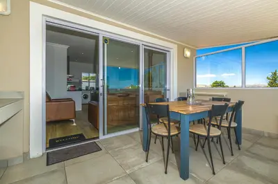 a dining room with a blue table and chairs at Irene Avenue Apartment with sea views in Somerset West