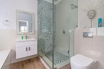 a bathroom with a shower with a toilet and a sink at Irene Avenue Apartment with sea views in Somerset West