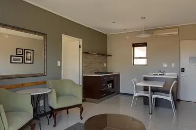a kitchen with chairs and a table and a sink at Protea Hotel by Marriott Cape Town Durbanville in Bellville