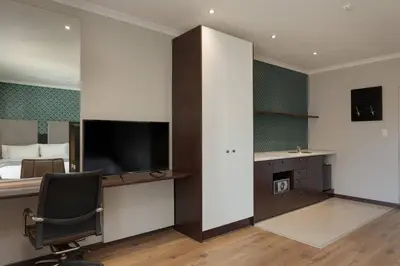 a bedroom with a desk and a chair and a bed at Protea Hotel by Marriott Cape Town Durbanville in Bellville