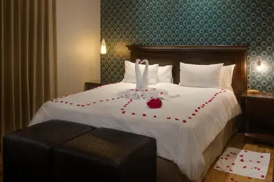 a hotel room with a bed with red roses on it at Protea Hotel by Marriott Cape Town Durbanville in Bellville
