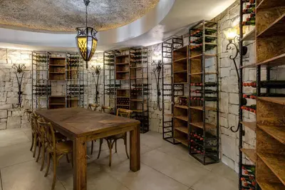 a dining room with a table and a wall of wine racks at Protea Hotel by Marriott Cape Town Durbanville in Bellville