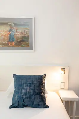 a bedroom with a bed with a painting on the wall at Rouana Guest Farm in Stellenbosch