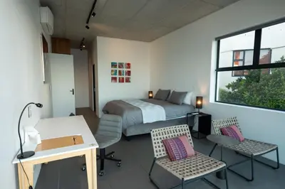 a bedroom with a bed and a desk and chairs at '22 Protea' - Luxury, Style and Elegance - Sleeps 12 in 6 En-suite Bedrooms in Gordonʼs Bay