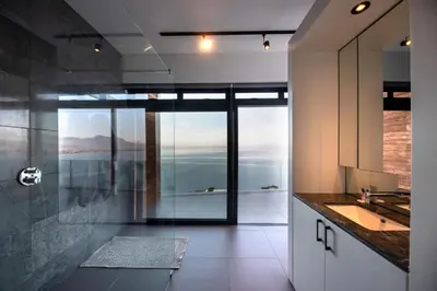 a bathroom with a sink and a view of the ocean at '22 Protea' - Luxury, Style and Elegance - Sleeps 12 in 6 En-suite Bedrooms in Gordonʼs Bay