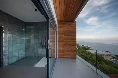 an open bathroom with a view of the ocean at '22 Protea' - Luxury, Style and Elegance - Sleeps 12 in 6 En-suite Bedrooms in Gordonʼs Bay