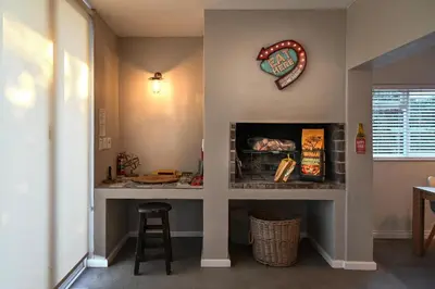 a living room with a counter and a clock on the wall at Die Badhuis, for Fabulous living! Sleeps 4, Private pool in Gordonʼs Bay