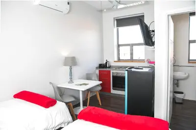 a room with a kitchen with a table and a refrigerator at Zeederberg Corner in Paarl