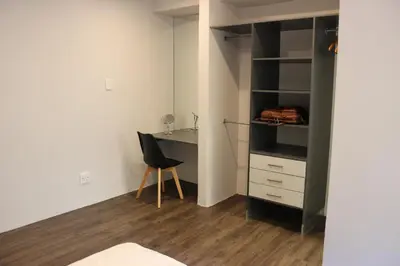 a bedroom with a desk and a chair in a room at Zeederberg Corner in Paarl