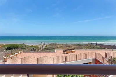 a view of a beach from a balcony with the ocean at Neptune Isle 214 in Cape Town
