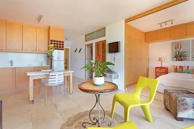 a kitchen and a living room with a bed and a table at Neptune Isle 214 in Cape Town