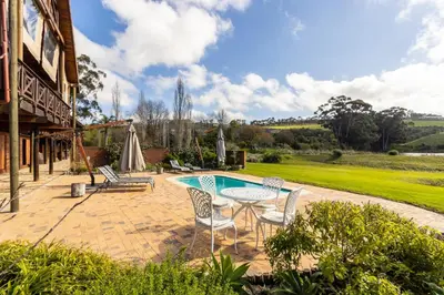 a patio with a table and chairs and a pool at The Log Collective in Stellenbosch