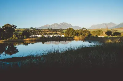 a view of a lake with mountains in the background at The Log Collective in Stellenbosch