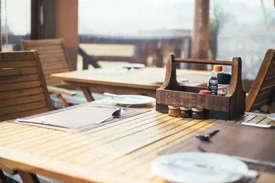 a wooden table with plates and utensils on it at The Log Collective in Stellenbosch