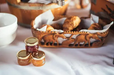 a basket of food and two bottles of honey on a table at The Log Collective in Stellenbosch