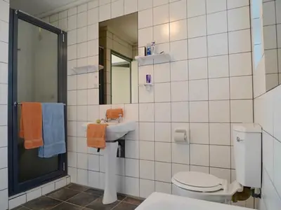 a bathroom with a toilet and a sink and a mirror at Sky house on Clarens in Bettyʼs Bay