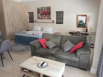 a living room with a couch and a bed at Cottage@Somerset in Somerset West