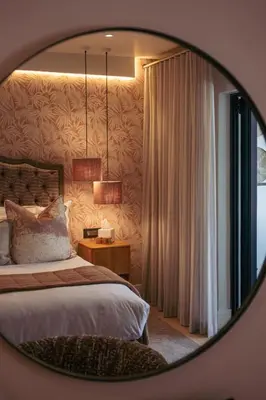 a bedroom with a bed and a mirror at Le Petit Manoir Boutique Hotel in Franschhoek