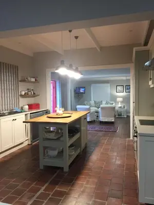 a kitchen with a island in the middle of a room at Acorn Cottage Hermanus in Hermanus