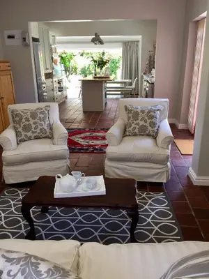 a living room with two chairs and a coffee table at Acorn Cottage Hermanus in Hermanus