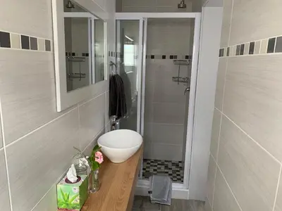 a bathroom with a sink and a shower at Acorn Cottage Hermanus in Hermanus