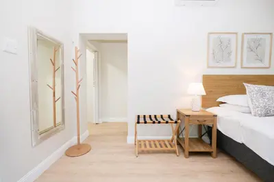 a bedroom with a bed and a table with a lamp at 10VDW Self Catering Apartments-Newly Renovated! in Durbanville