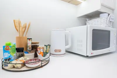 a counter with a microwave and a plate of food at 10VDW Self Catering Apartments-Newly Renovated! in Durbanville