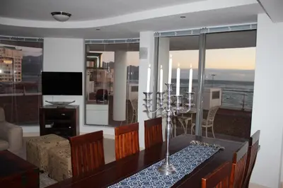 a living room with a dining room table with a view of the ocean at Hibernian Towers 505 in Strand