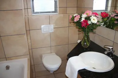 a bathroom with a sink and a vase of flowers at Hibernian Towers 505 in Strand